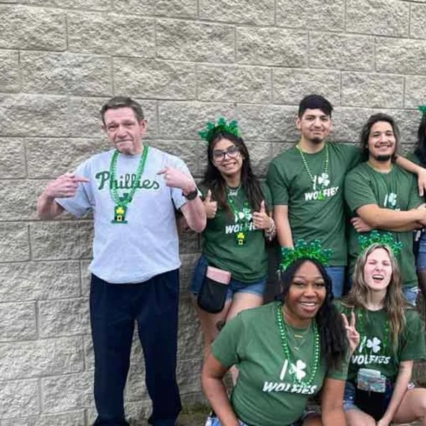 Wolfies Restaurant and Sports Bar staff in green shirts and St. Patrick's Day accessories.