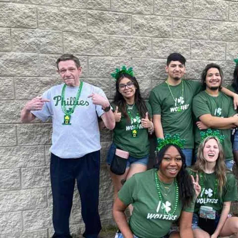 Wolfies Restaurant and Sports Bar staff in green shirts and St. Patrick's Day accessories.