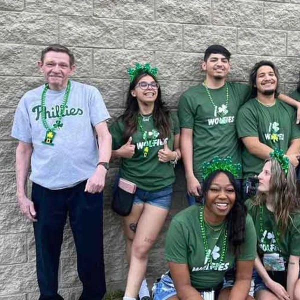 Wolfies Restaurant and Sports Bar staff in green shirts and shamrock accessories for St. Patrick's Day.