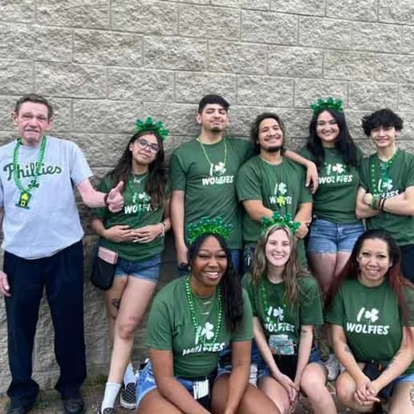 Wolfies Restaurant and Sports Bar staff in green shirts and shamrock accessories for St. Patrick's Day.